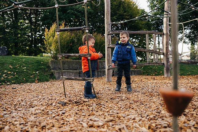 Kinder auf dem Spielplatz mit Fallschutzschnitzel