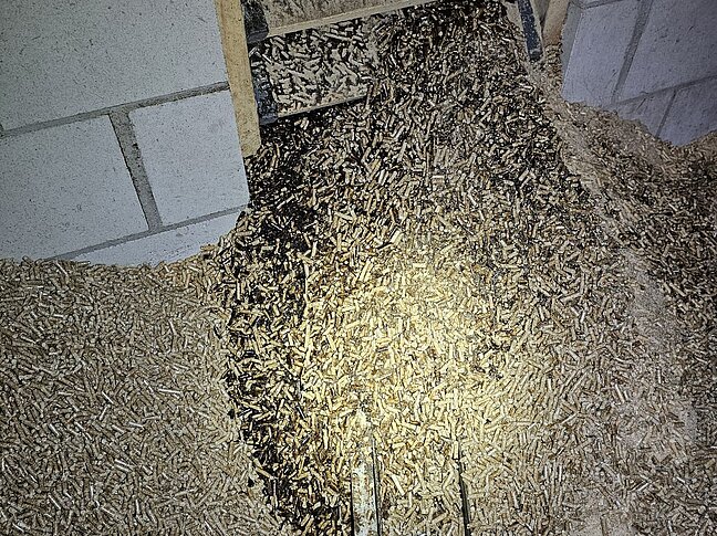 angebrannte Holzpellets im Lagerraum