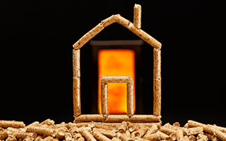 Haus aus Pellets mit Flammen im Hintergrund